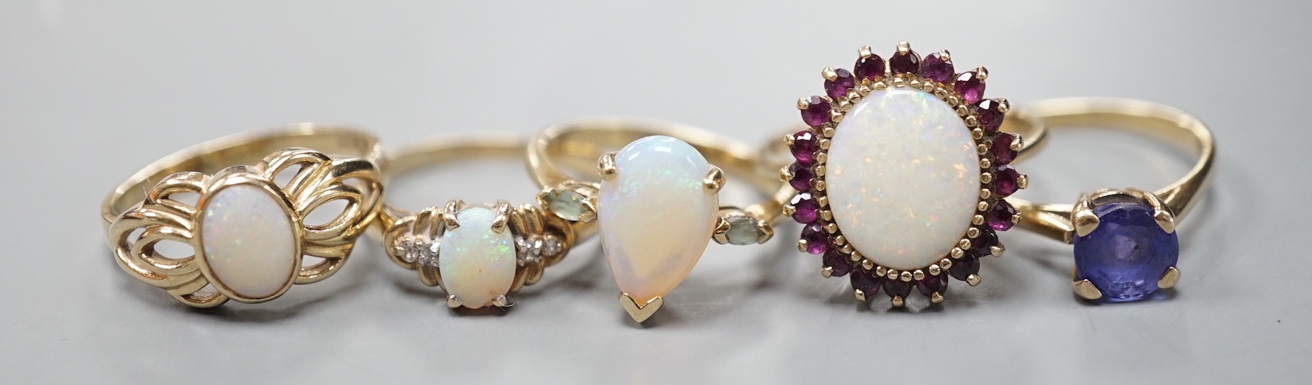 Five assorted modern 9ct gold and gem set dress rings, including white opal and garnet oval cluster, white opal and diamond chip and single stone white opal